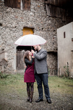 a couple looking into each other's eyes under a umbrella 