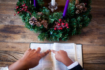 mother and son reading a Bible near an Advent wreath 
