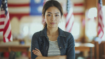 Portrait of a young Asian American woman at a polling station, with American flags in the background, embodying civic participation.