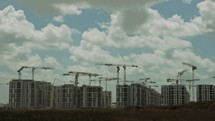 Timelapse of a large construction site with many cranes working over buildings