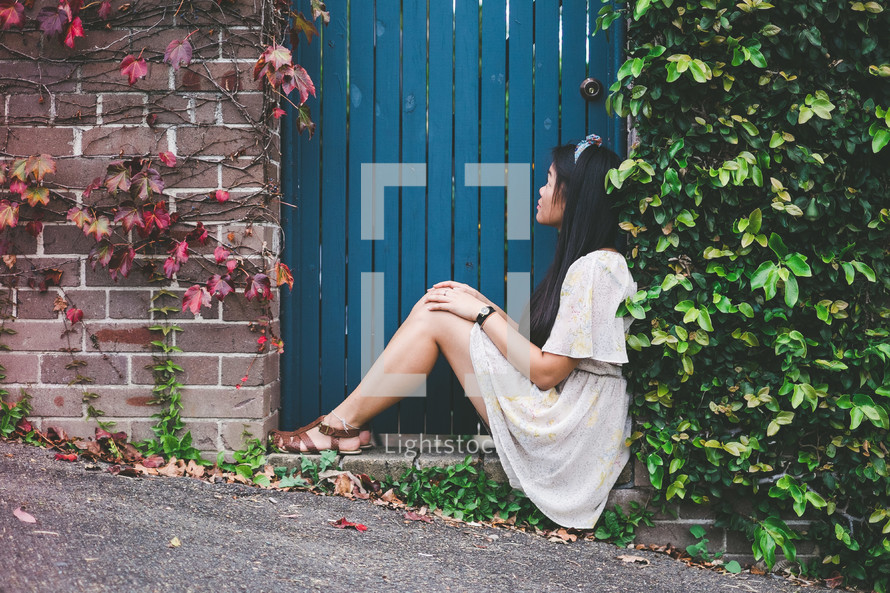 woman sitting at a gate entrance 