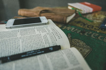A cell phone on a Bible open to Corinthians.