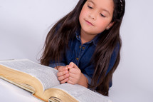 Girl reading an open Bible.