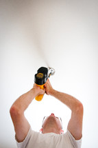 man using an electric screw driver 