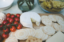 cheese wheel, cherry tomatoes, crackers 