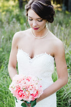 a bride holding a bouquet of pink flowers 