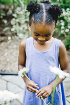An African American girl holding a spring flowers 