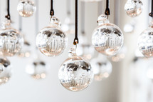 glass balls hanging on string at a wedding 