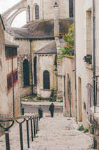 person walking up steps and view of a cathedral in France 
