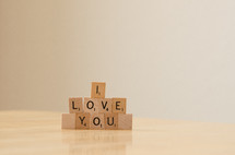 "I love you" spelled out in stacked scrabble tiles