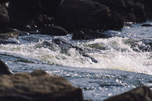 splashing ocean water on rocks at the shore