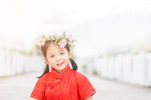 a little girl in a red traditional Chinese dress 