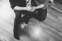 a couple sitting on a floor holding hands 