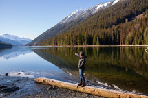 a man standing on a lake shore in Canada 