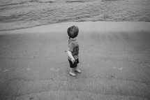 toddler boy barefoot in the sand 