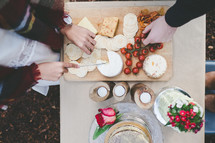 cheese wheel, tomatoes, and crackers 