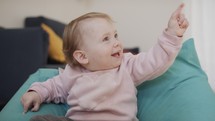 Cute baby girl playing at home and smiling to the camera