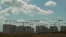 Timelapse of a large construction site with many cranes working over buildings