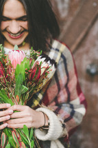 a smiling woman holding a bouquet of flowers 