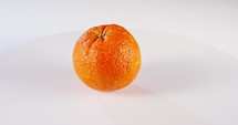 Close up of an Orange rotating on a white background