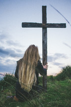 woman kneeling in front of a cross 