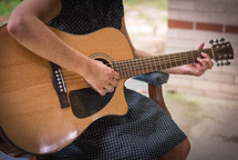 torso of a woman playing a guitar 