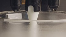 Macro shot of espresso machine preparing a latte cup with foamed milk