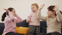 Baby girl playing with 2 young girls, laughing and smiling