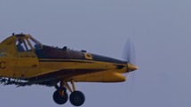 Crop duster flying and spraying chemicals over a cotton field