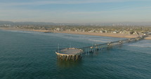 Pier on Venice Beach, panning aerial. Aerial view of the pier near Venice beach in Los Angeles during sunset. 