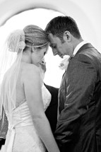Bride and groom praying together at wedding alter