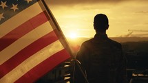 American soldier salutes sunset light