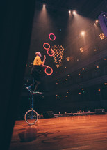 man juggling on a unicycle 