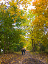 couple walking on a dirt road in fall 