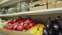 Large variety of vegetables and fruits on supermarket shelves.
