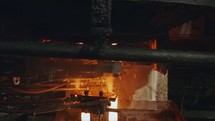 Molten glass pouring out of a Glass melting furnace in a bottle production facility. Glass recycling
