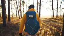 Travel Concept. Silhouette hiker man travelling alone with backpack. Traveling alone thinking about life. A man is walking along against the sunset.