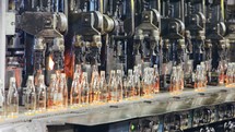 Glass bottles production. Glass bottles on a conveyor belt in an industrial glass production facility