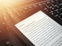 ebook reader with The Holy Bible on a laptop keyboard