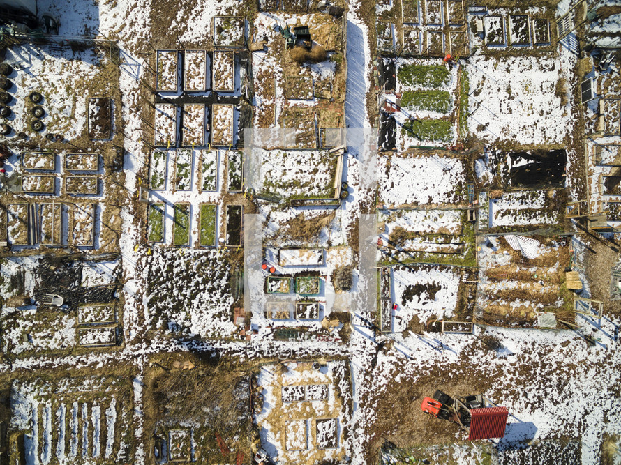 aerial view over snow on farmland 