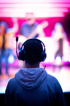 a man with headphones watching a worship service 