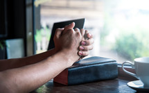 a man praying over a Bible in a window 