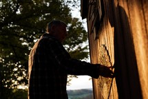 man standing next to a barn 