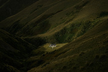 house between two green Mountains 