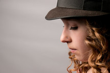 A girl in a hat with a nose piercing.