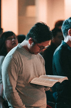 a man reading a Bible during a worship service 