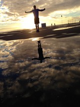 reflection of a man jumping in a puddle 