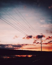power lines and rural road at sunset 