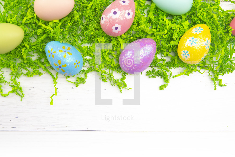 Easter eggs and green grass on a white background 
