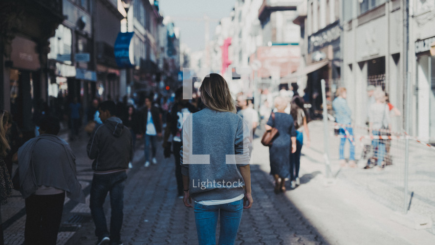 woman walking down a city sidewalk 